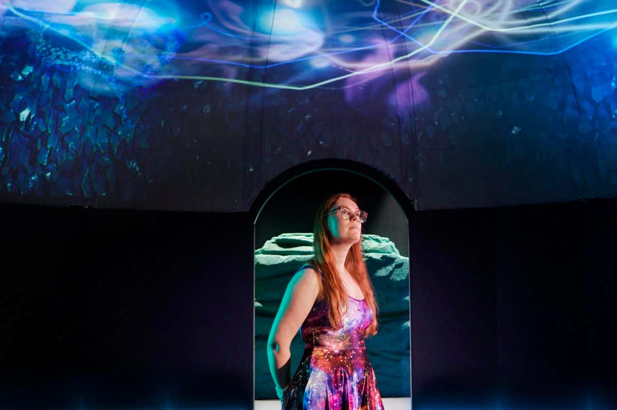 Visitors inside the Off-World section of the exhibition, while a swarm of bioluminescent creatures emerge above their heads