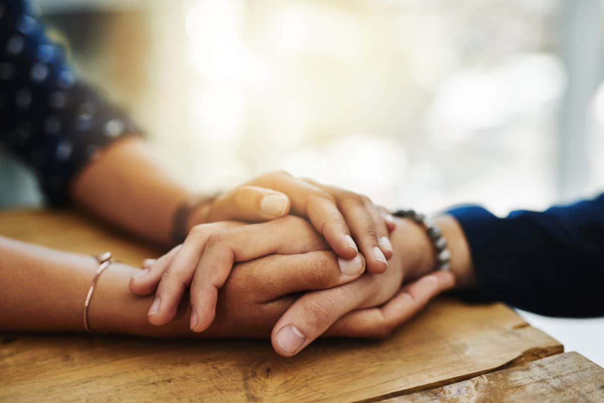 Closeup shot of two unrecognizable people holding hands in comfort