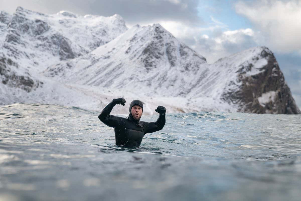 Chris Hemsworth celebrates while surfing. (National Geographic for Disney+/Craig Parry)