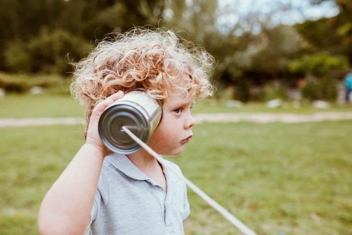 Boy listening to tin can on a string