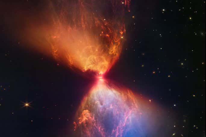 The protostar within the dark cloud L1527, shown in this image from NASA?s James Webb Space Telescope Near-Infrared Camera (NIRCam), is embedded within a cloud of material feeding its growth. Ejections from the star have cleared out cavities above and below it, whose boundaries glow orange and blue in this infrared view. The upper central region displays bubble-like shapes due to stellar ?burps,? or sporadic ejections.