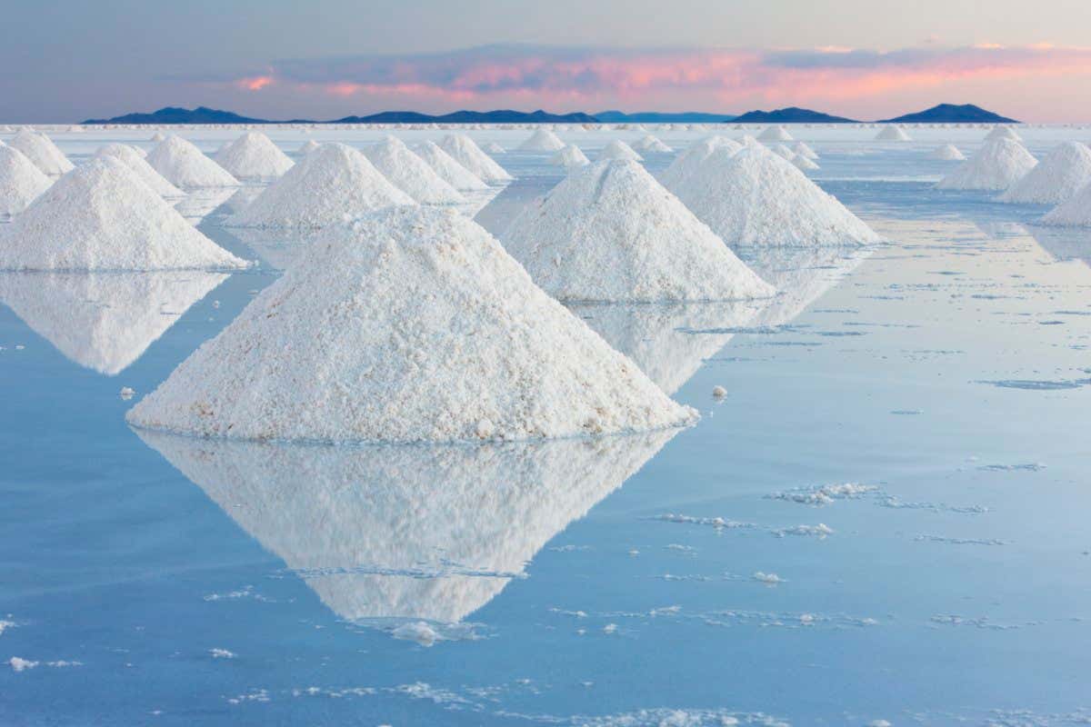 Conical mounds of salt reflected in the shallow water on the Salar de Uyuni at sunset