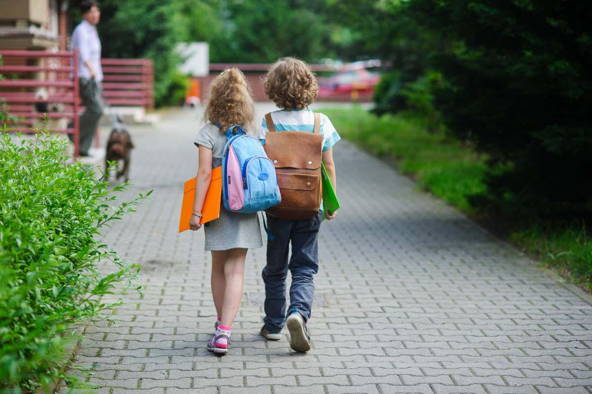 Two pupils of primary school walk hand in hand