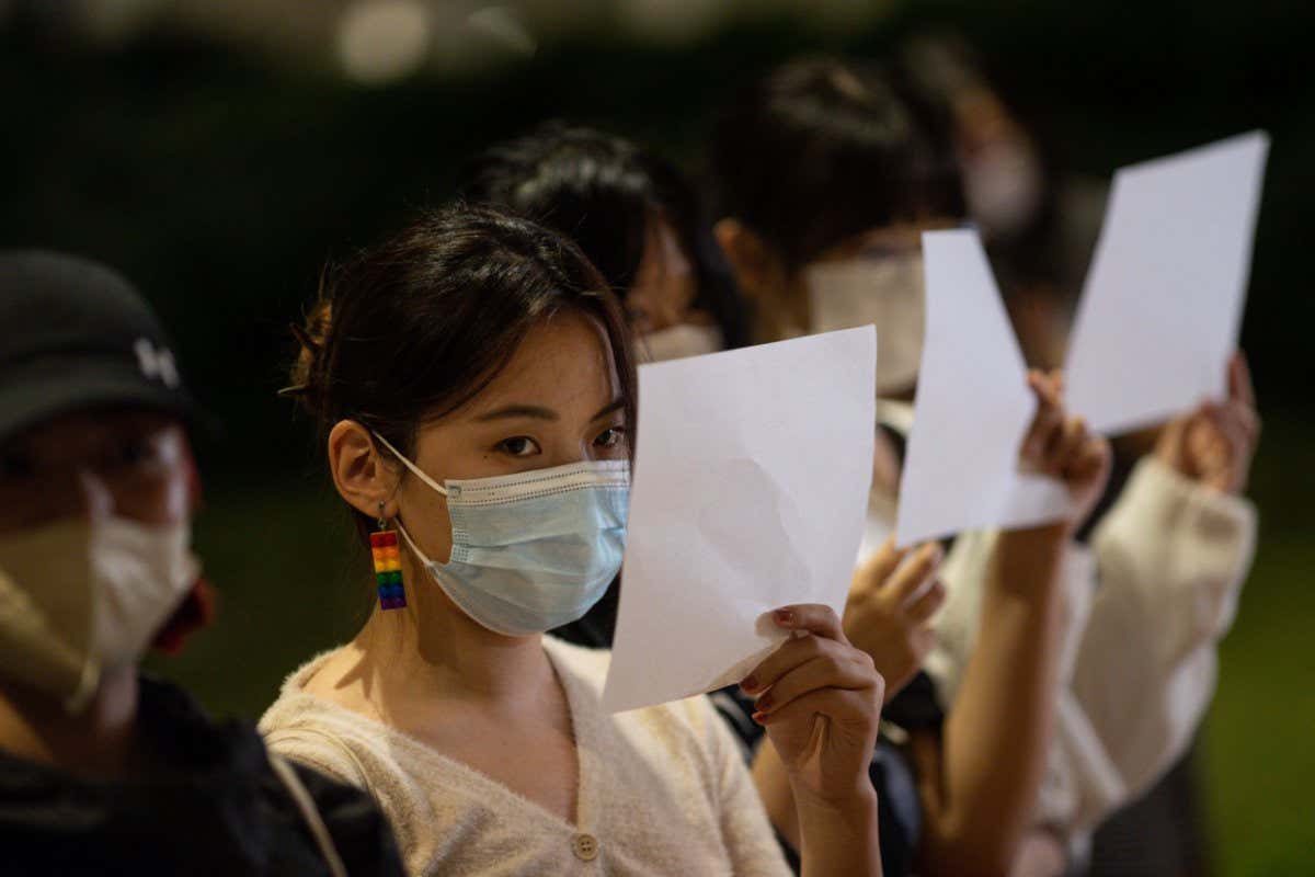 Mandatory Credit: Photo by JEROME FAVRE/EPA-EFE/Shutterstock (13641875g) Mainland Chinese students hold sheets of blank paper during a vigil for the victims of China's zero-COVID policy and the victims of the Urumqi fire at the University of Hong Kong in Hong Kong, China, 29 November 2022. Protests against China's strict COVID-19 restrictions have erupted in various cities including Beijing and Shanghai, triggered by a tower fire that killed 10 people in Xinjiang's capital, Urumqi. University students hold a vigil for the victims of China's zero-COVID policy, Hong Kong - 29 Nov 2022
