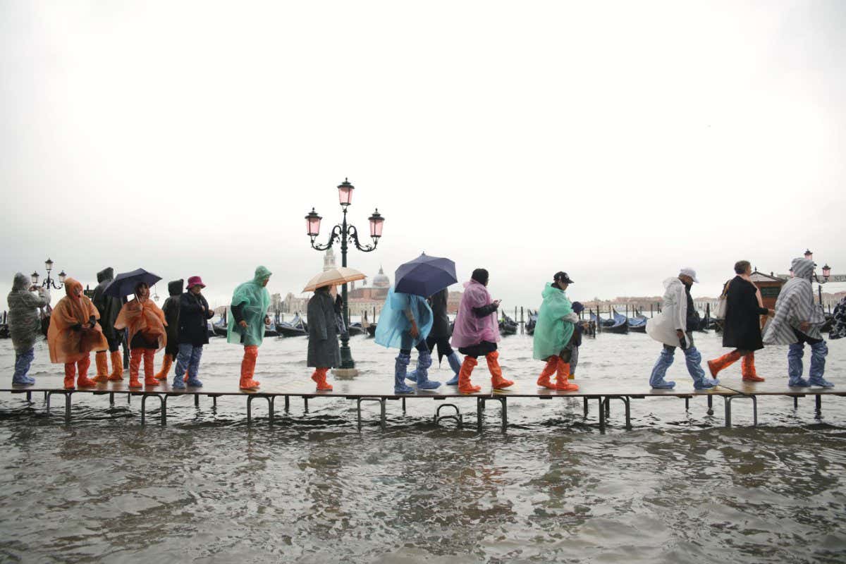 People walk in a flooded St Mark's Square