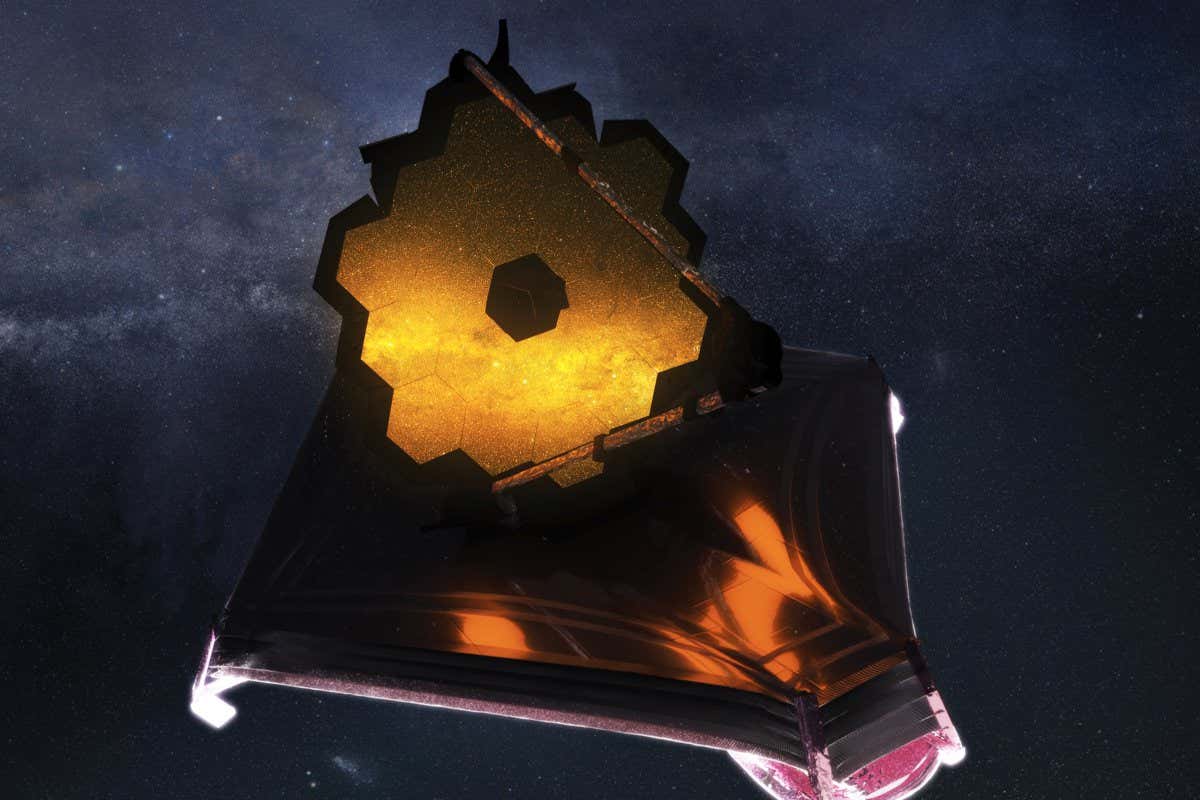 Image description: An illustration of the James Webb Space Telescope deployed in space. The telescope has a large mirror made of hexagons that are being illuminated by the galaxy being observed. Otherwise the top side of the telescope is in the dark. The underside is being lit by the sun. The telescope is set against a starry background.