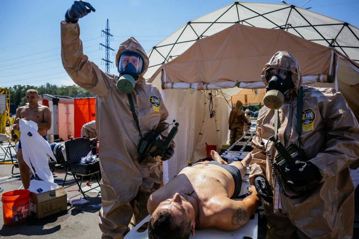 TOPSHOT - Ukrainian Emergency Ministry rescuers attend an exercise in the city of Zaporizhzhia on August 17, 2022, in case of a possible nuclear incident at the Zaporizhzhia nuclear power plant located near the city. - Ukraine remains deeply scarred by the 1986 Chernobyl nuclear catastrophe, when a Soviet-era reactor exploded and streamed radiation into the atmosphere in the country's north. The Zaporizhzhia nuclear power plant in southern Ukraine was occupied in the early days of the war and it has remained in Russian hands ever since. (Photo by Dimitar DILKOFF / AFP) (Photo by DIMITAR DILKOFF/AFP via Getty Images)