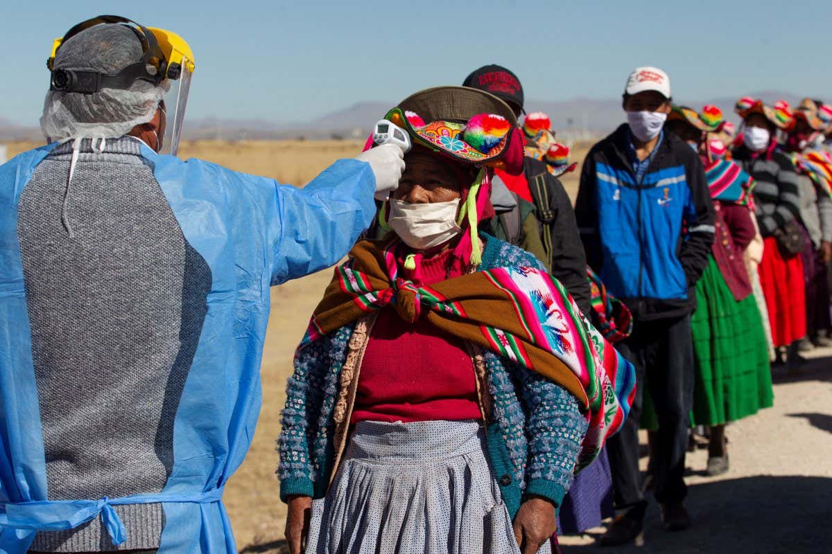 A person has their temperature checked before entering a market in Coata, Peru, in July 2020