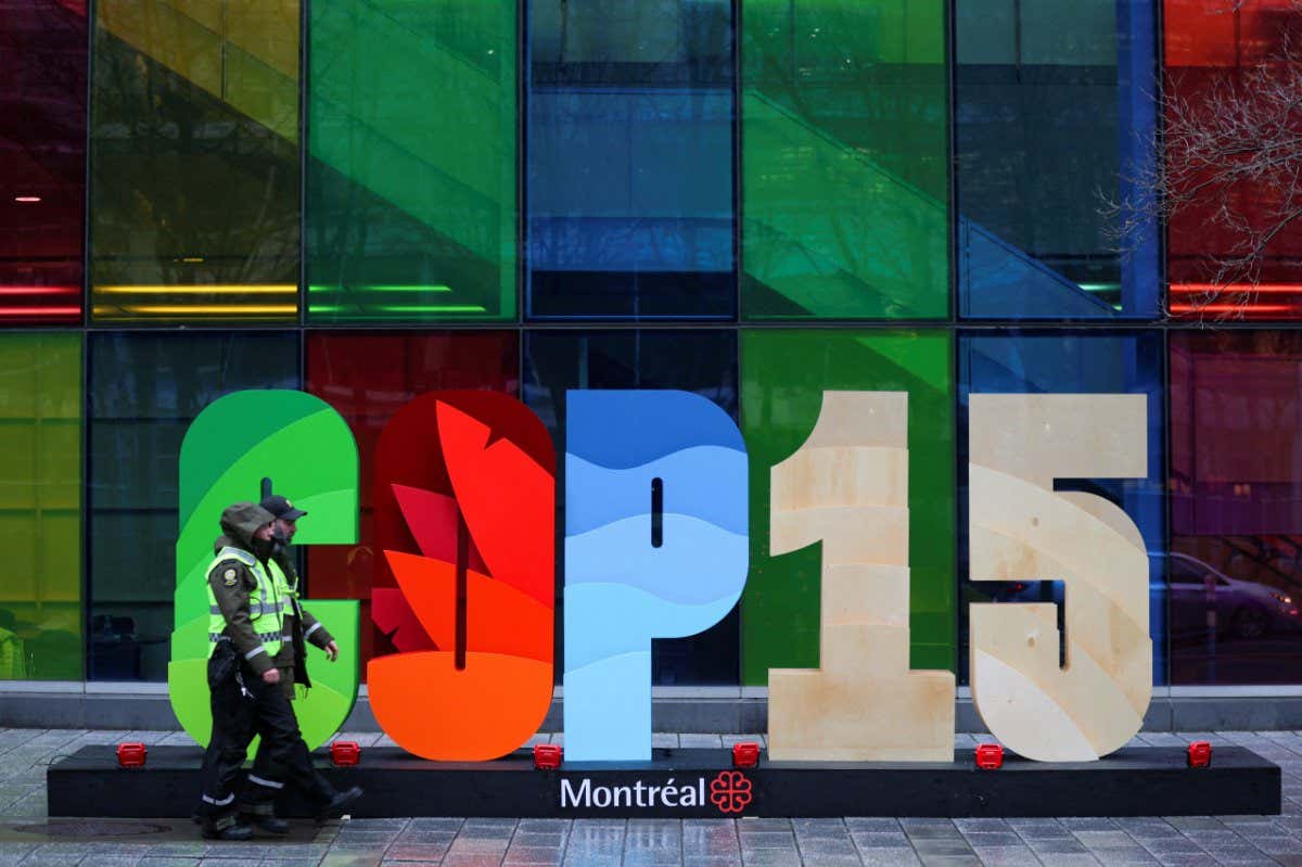 Police officers walk past a sign as they patrol outside the Palais de Congres, during the opening of COP15, the two-week U.N. biodiversity summit in Montreal, Quebec, Canada December 6, 2022. REUTERS/Christinne Muschi - RC2H0Y92YQSE