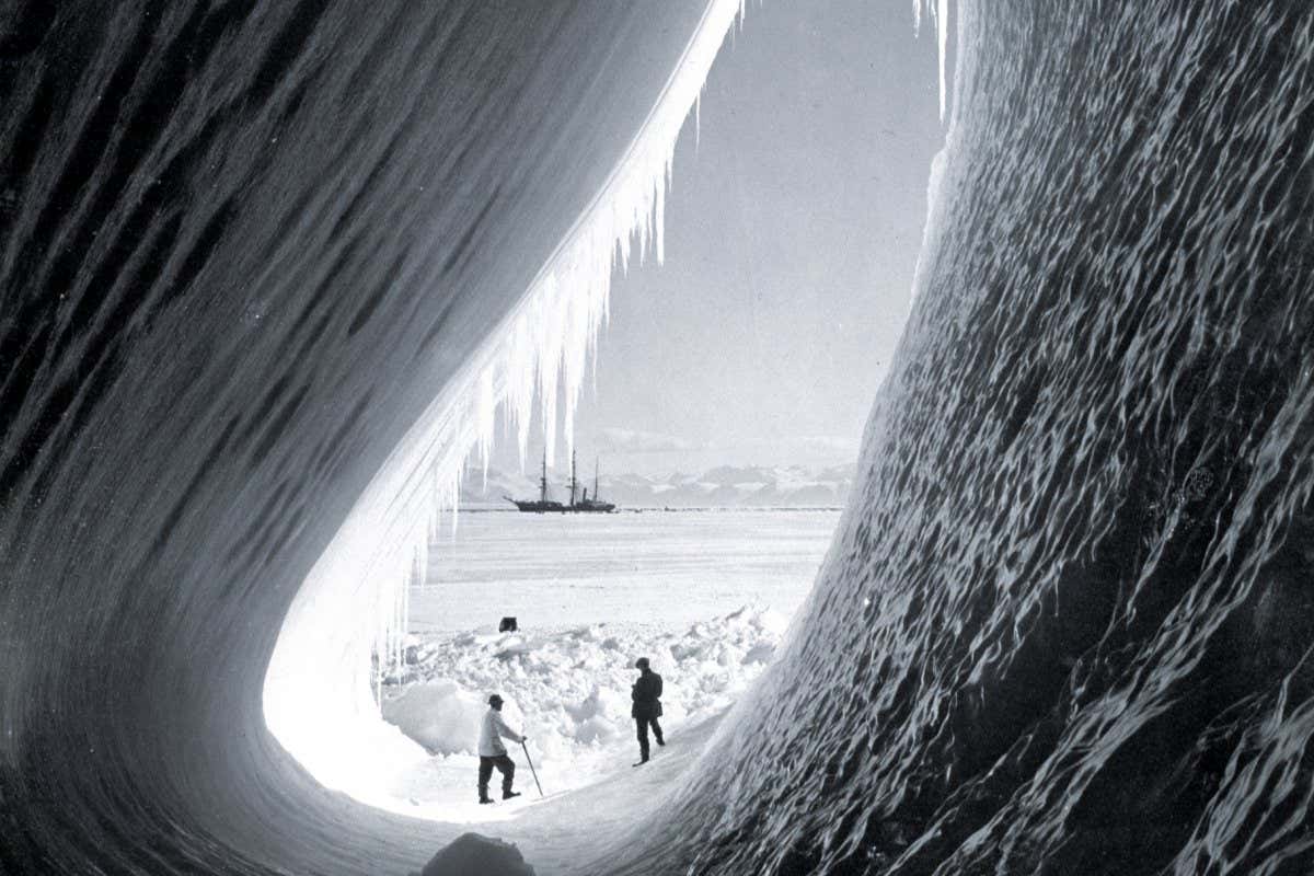 Grotto in a berg, Terra Nova in distance Taylor and Wright (interior), Antarctica, 5th January 1911. British Antarctic Expedition 1910-1913. (Photo by Herbert Ponting/Royal Geographical Society via Getty Images)