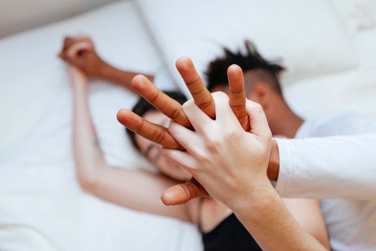Interracial heterosexual couple holding hands at home. Millennial young love between two different races; Shutterstock ID 1493320925; purchase_order: -; job: -; client: -; other: -