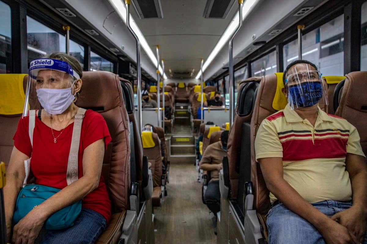 MANILA, PHILIPPINES - AUGUST 19: Commuters are seen wearing face masks and face shields inside a bus on August 19, 2020 in Quezon city, Metro Manila, Philippines. President Rodrigo Duterte relaxed quarantine measures in the Philippine capital in a bid to boost the country's tanking economy despite having the most coronavirus cases in Southeast Asia. The Philippines' health ministry has so far confirmed 173,774 cases of the coronavirus, a third of which were recorded in the last two weeks. (Photo by Ezra Acayan/Getty Images)