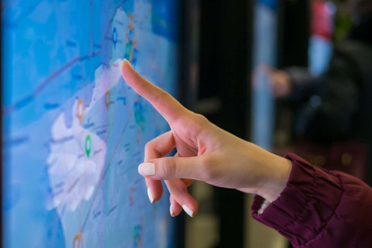 A woman's hand using a touchscreen display