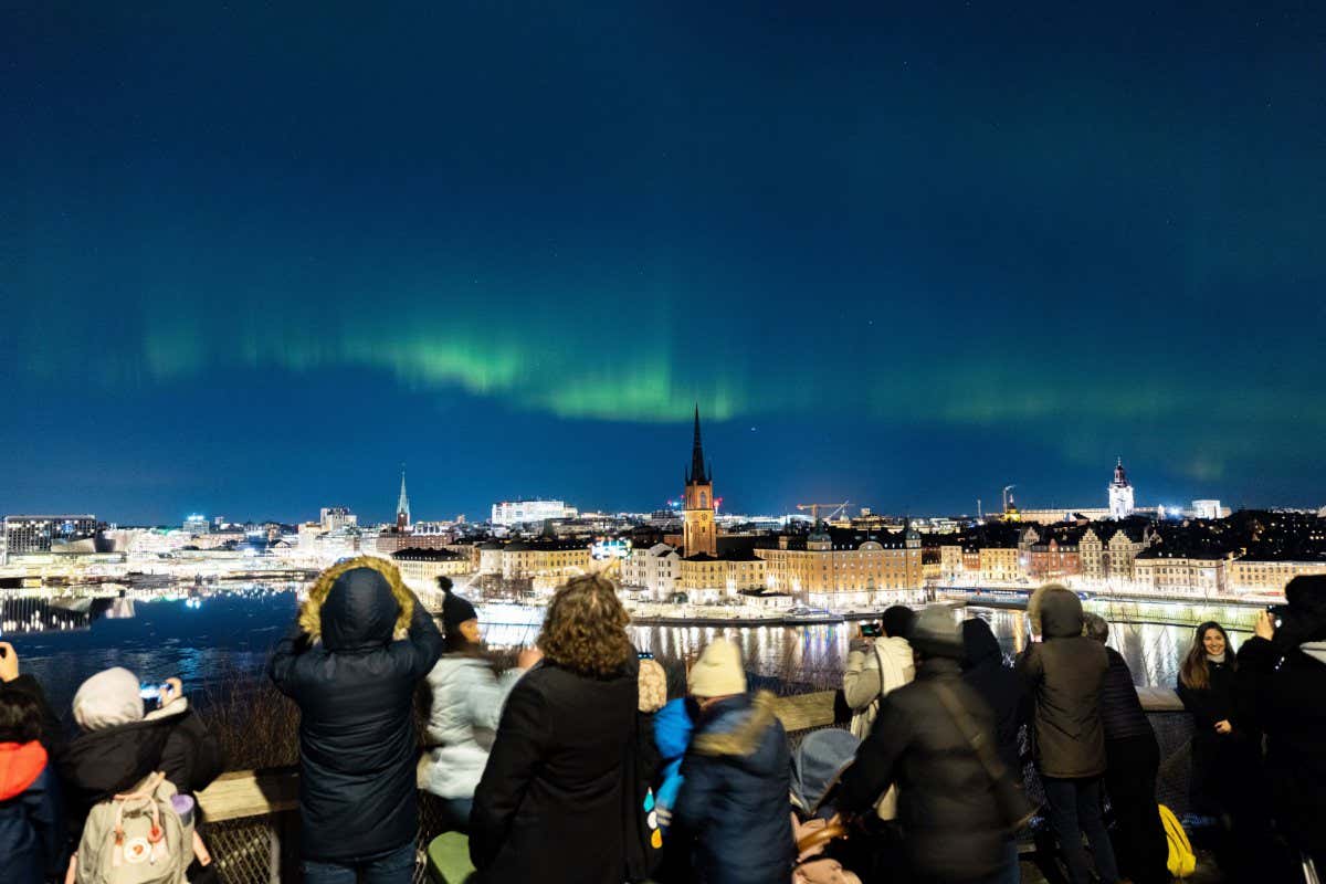 People viewing the northern lights, aurora borealis, in central Stockholm, Sweden, 27 February 2023