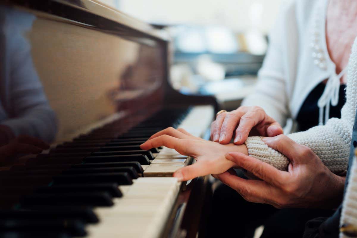 experienced hand of the old music teacher helps the child pupil; Shutterstock ID 379622230; purchase_order: -; job: -; client: -; other: -