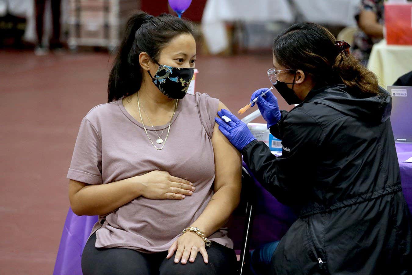 LOS ANGELES, CA - NOVEMBER 03: Nicole Fahey, of Altadena, six months pregnant, receives a Pfizer vaccination booster shot from RN Veronique (cq) Vida (cq) at Eugene A. Obregon Park on Wednesday, Nov. 3, 2021 in Los Angeles, CA. The County of Los Angeles, including Supervisor Hilda L. Solis, Dr. Barbara Ferrer, Director of Public Health, and Norma Edith Garc?a-Gonz?lez, Director of Parks and Recreation, will host a media event kicking off COVID-19 vaccinations for children ages 5-11 in Los Angeles County. The COVID-19 vaccine manufactured by Pfizer and BioNTech is proposed to be given in two 10-microgram (mcg) doses administered 21 days apart. (Gary Coronado / Los Angeles Times via Getty Images)