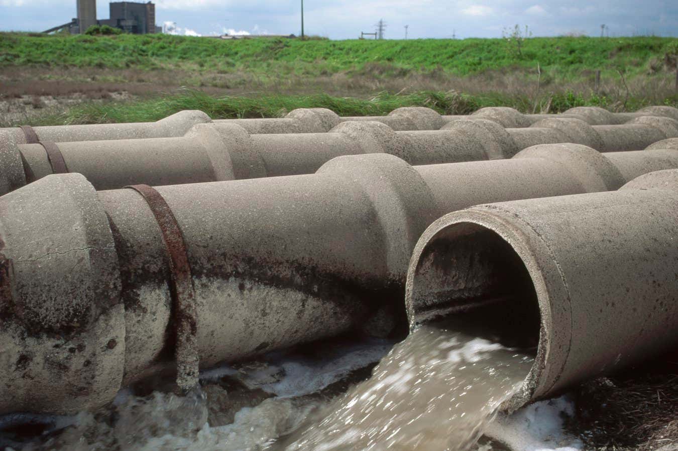 Waste water flowing into a British river from concrete pipes