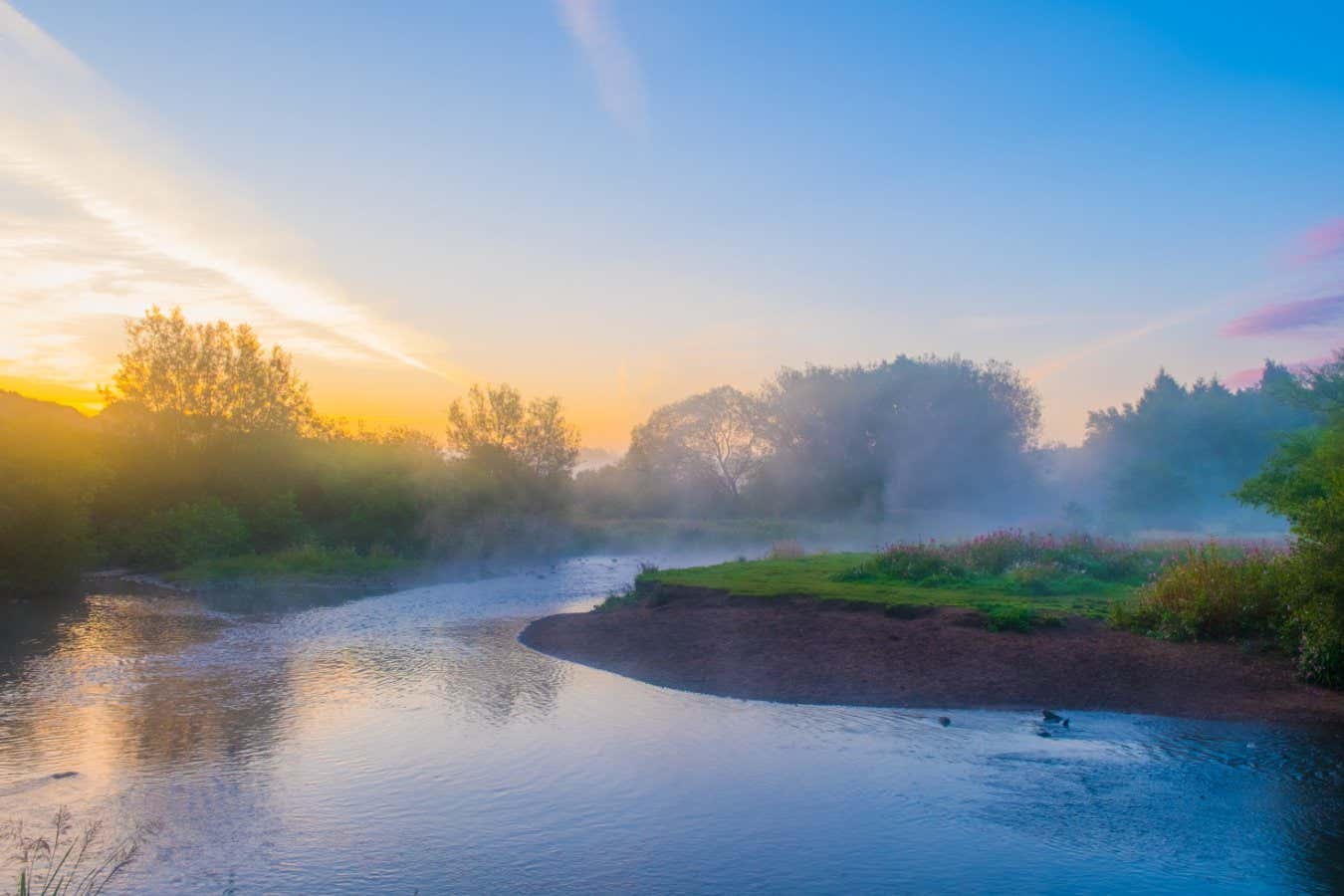 River Tame i Reddish Vale meandering around a grassy bank
