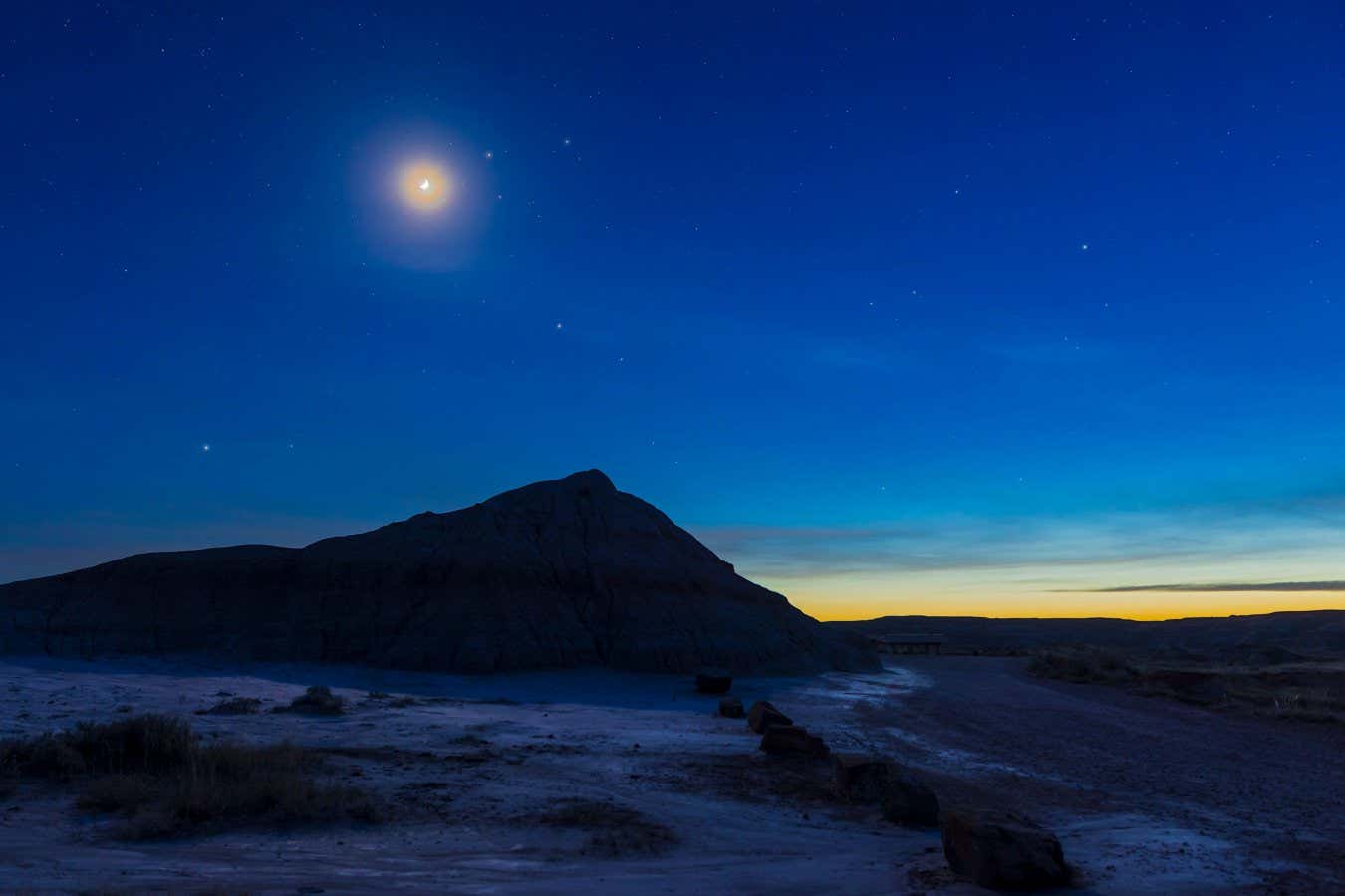 2GYKRJN The waxing crescent Moon near the stars Castor and Pollux in Gemini, with Mars below, as the last of the winter stars set into the western twilight on