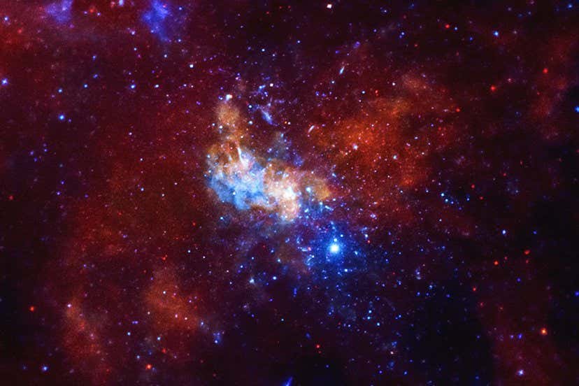 An image of an area of space filled with red and blue gas, and scattered stars