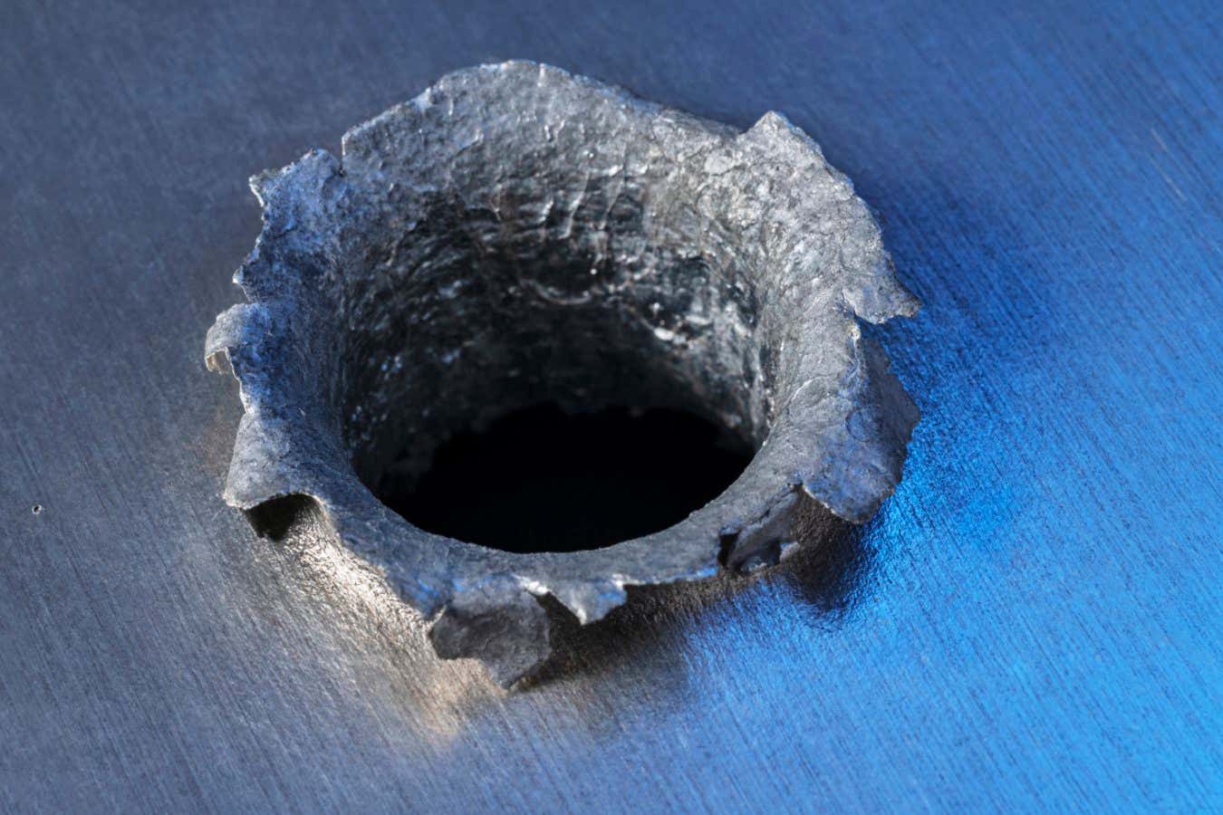 PLASTIC INTO METAL This aluminium plate has been punctured by a plastic projectile. While the aluminium is stronger than the plastic, the damage is done because of the energy carried in the speeding projectile. The movement energy of a small object is mostly determined by its speed, and when the speed is kilometres per second, the energy is enormous. This is released on impact, creating the equivalent of a small explosion. This piece is part of Donald Kessler?s private collection.