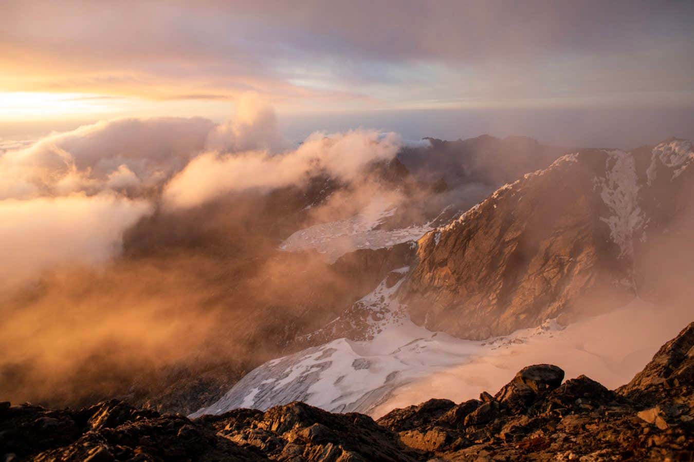 A shoulder of Alexandra Peak, the second heighest peak in the Rwenzori range, as seen from Margherita Peak. In the valley between the two peaks lies Stanley Glacier. The glacier was once so high that guides could lead clients across it on a gentle walk between the peaks. Today the face of the mountain is exposed as the glacier dies.