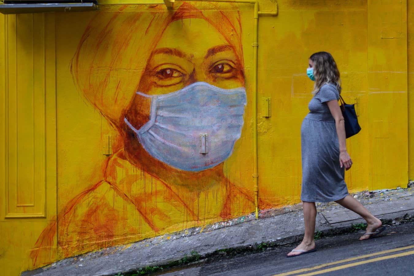A pregnant woman walking in Hong Kong in March 2020