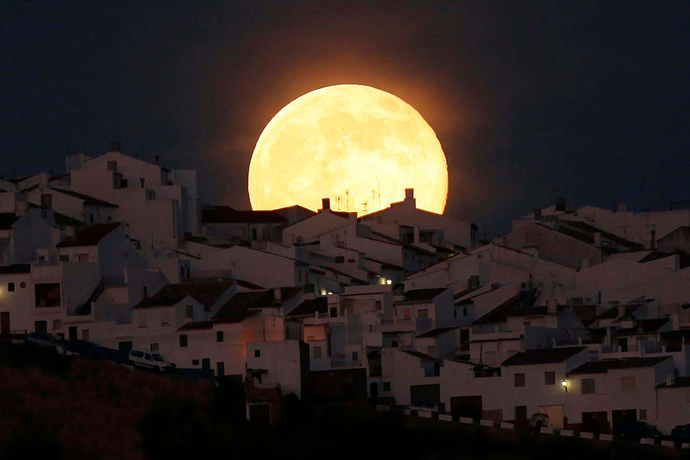 The Supermoon rises over houses in Olvera, in the southern Spanish province of Cadiz, July 12, 2014. Occurring when a full moon or new moon coincides with the closest approach the moon makes to the Earth, the Supermoon results in a larger-than-usual appearance of the lunar disk. REUTERS/Jon Nazca (SPAIN - Tags: SOCIETY CITYSCAPE TPX IMAGES OF THE DAY) - GM1EA7D0FC401