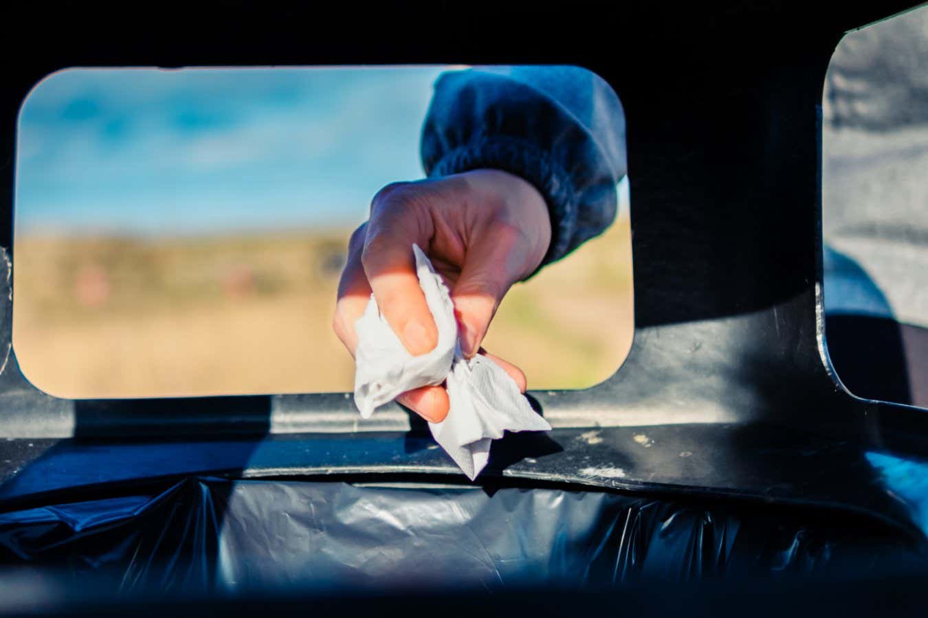 Someone throwing rubbish in bin. rubbish bin. Trash.