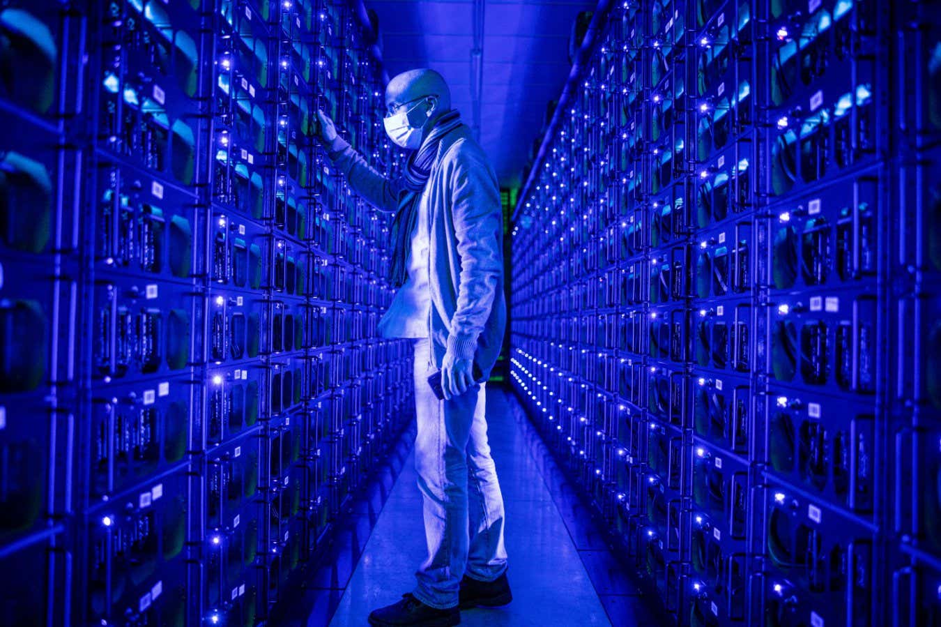 An employee among mining rigs at the Evobits crypto farm in Cluj-Napoca, Romania