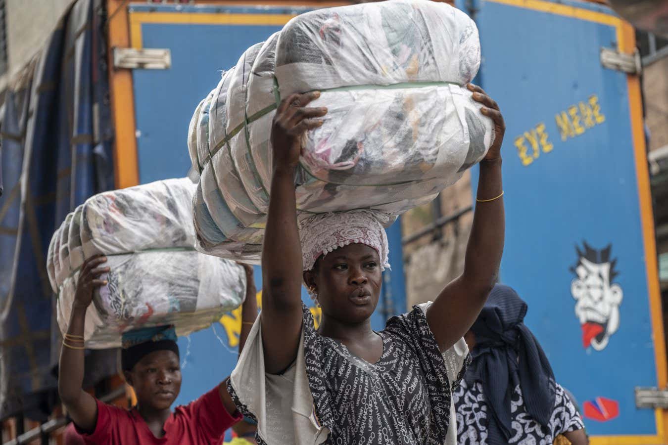 Female porters, known as 'kayayei', carry bales of second-hand garments on their heads at the Kantamanto textile market in Accra, Ghana, on Thursday, Sept. 15, 2022. The rise of fast fashionand shoppers preference for quantity over qualityhas led to a glut of low-value clothing that inordinately burdens developing countries. Photographer: Andrew Caballero-Reynolds/Bloomberg via Getty Images