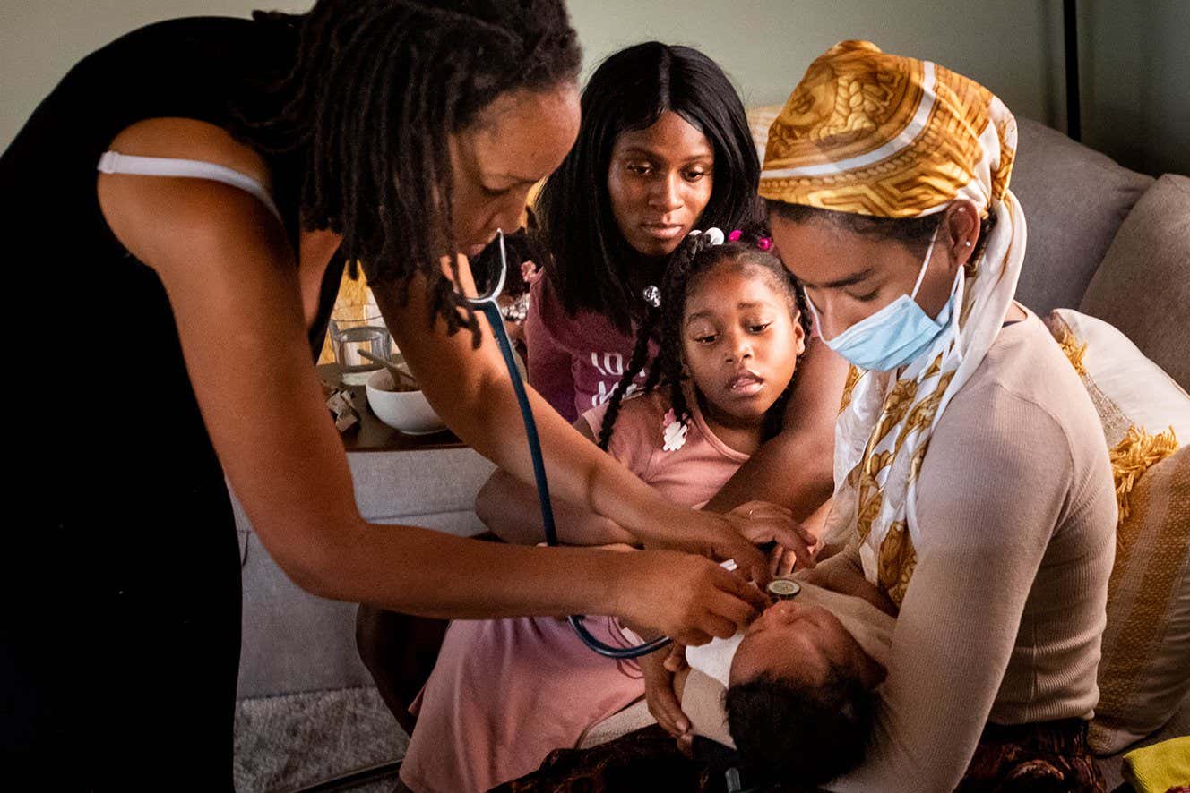 , CA - May 26:Aysha-Samon Stokes and her daughter Nyla, 6, watch Midwife Allegra Hill and student Midwife Maryam Karim take the heartbeat of two-week-old Nikko during a postpartum visit to the South Los Angeles birthing center, Kindred Space LA, on Wednesday, May 26, 2021 where he was born on Mothers Day night. With fear of another C-section and fear of the high mortality rate in the hospitals among women like herself Stokes found her midwife in her third trimester. (Photo by Sarah Reingewirtz/MediaNews Group/Los Angeles Daily News via Getty Images)