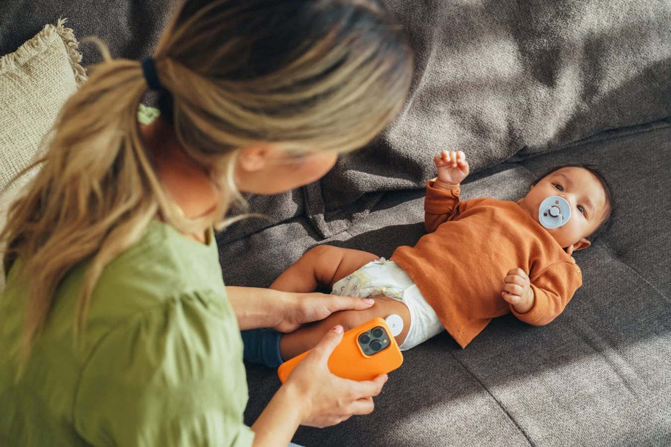 A baby wearing a sensor for measuring blood glucose levels