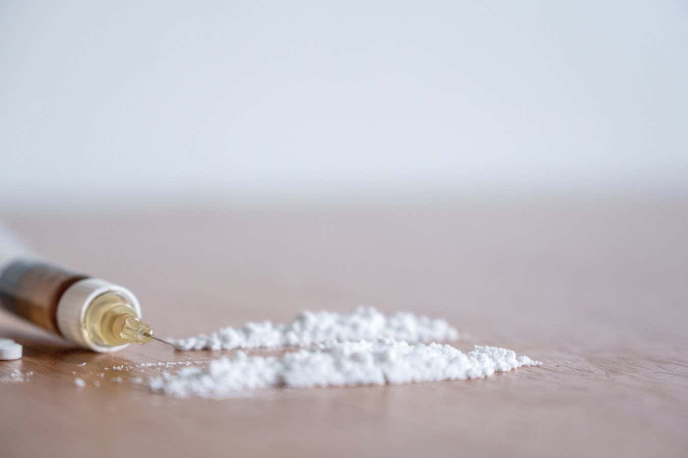 Heroin syringe needle with heoin or cocaine powder on the table.; Shutterstock ID 1104404324; purchase_order: -; job: -; client: -; other: -