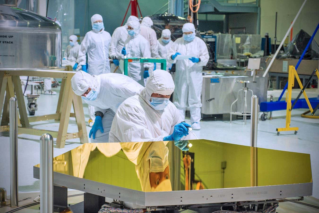 Webb?s 18 mirror segments, each 1.32 meters wide, were sent by truck from its manufacturer, Ball Aerospace, in Colorado, to NASA Goddard in Maryland starting in September 2012?at first one by one and then in twos and threes, as they were manufactured over a period of about a year. Each segment is relatively light, about 20 kilograms, or 46 pounds, made from beryllium with a thin coating of gold only 4.3 grams, or 0.12 ounces. Here, Matt Macias of Northrop Grumman shines a light to assess and document any artifacts on the gold surface. Normally the clean room was noisy with activity, but there was a prolonged hush when the lid for the container came off and we all saw the mirrors for the first time. I remember standing in the glow of the gold and realizing that I had never stood next to something so precious. Page 64