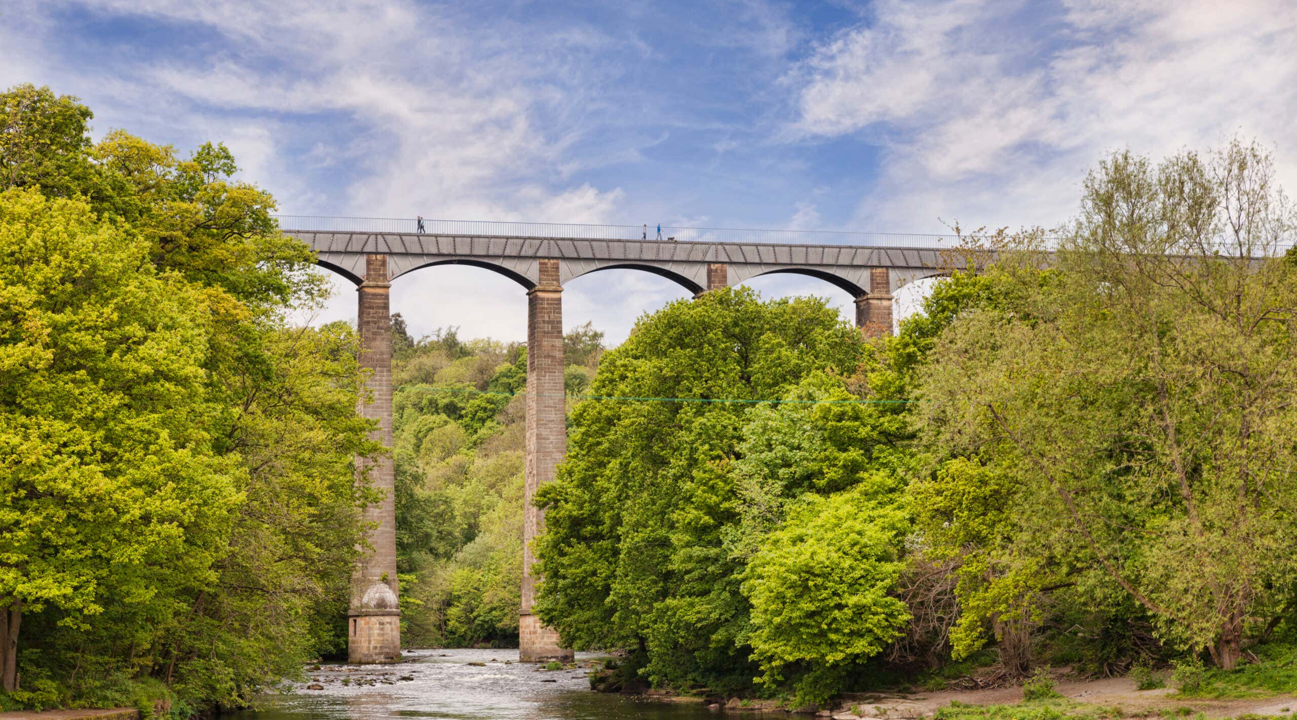 Pontcysyllte Aqueduct, built by Thomas Telford, and a World Heritage Site, reflecting in the River Dee, with people walking across, near Llangollen, County Borough of Wrexham, Wales, UK