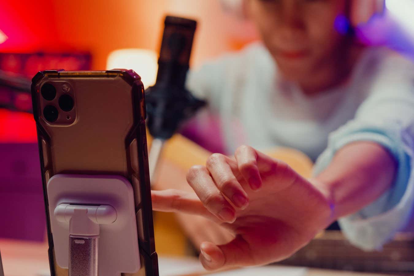 Close-up Happy Asian girl influencer wear headphone with guitar record podcast onair online live streaming talk follower comment and audience on phone at home studio. Female podcaster, Audio podcast.