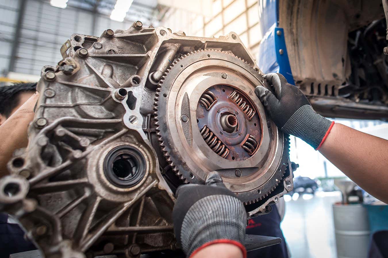Car mechanic fixing flywheel