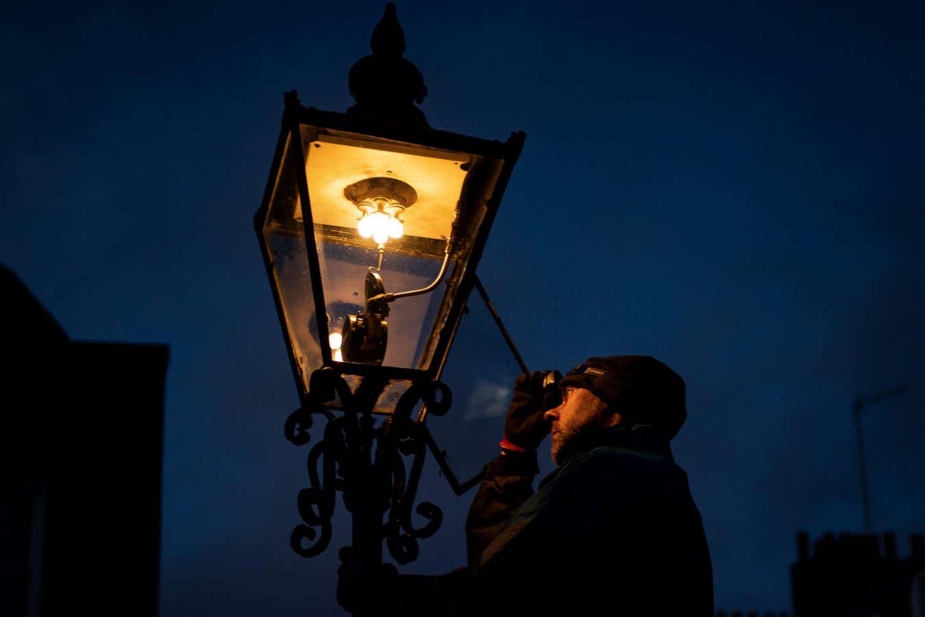 2HN6JW3 Jim, a gas lamp lighter engineer from British Gas, works in St John Smith Square, Westminster, London. Over 300 gas fuelled lamps still remain in Westminster and around 1,500 gas lamps, dating back 200 years old, continue to light the capital. Picture date: Monday February 14, 2022.