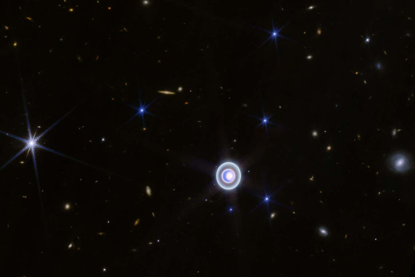 This JWST picture of Uranus shows five more moons, shining like blue stars around the planet: Oberon, Umbriel, Ariel, Miranda and Titania
