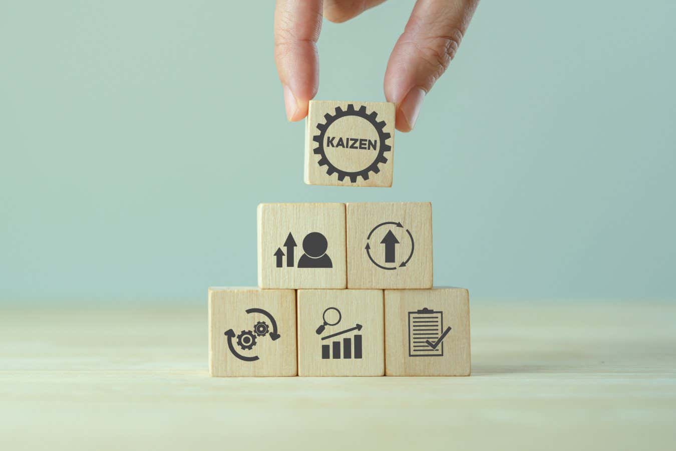 Kaizen concept; the continuous improvement in business for efficiency and effectiveness. Kaizen cycle icon on wood cubes; improve, continuous, process, result, standard solution. Quality improvement.