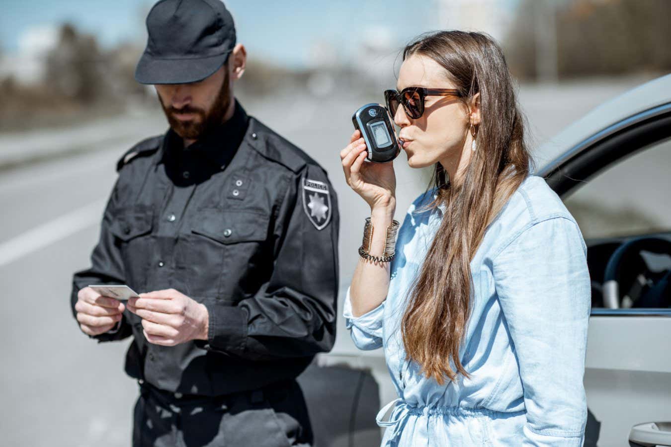 Policeman checking woman driver for alcohol intoxication