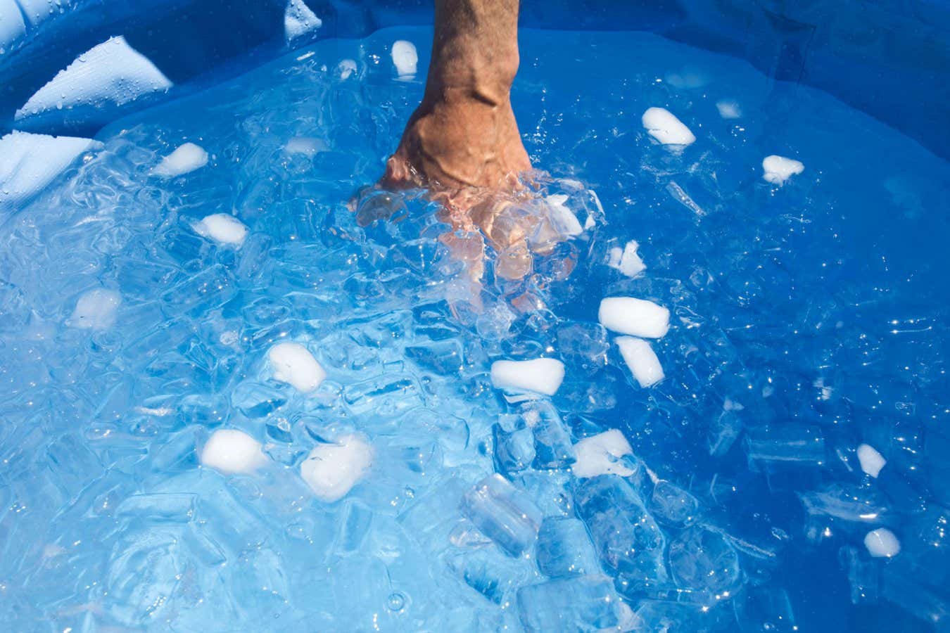 2A7RF8J Hand inside ice bath in swimming pool.