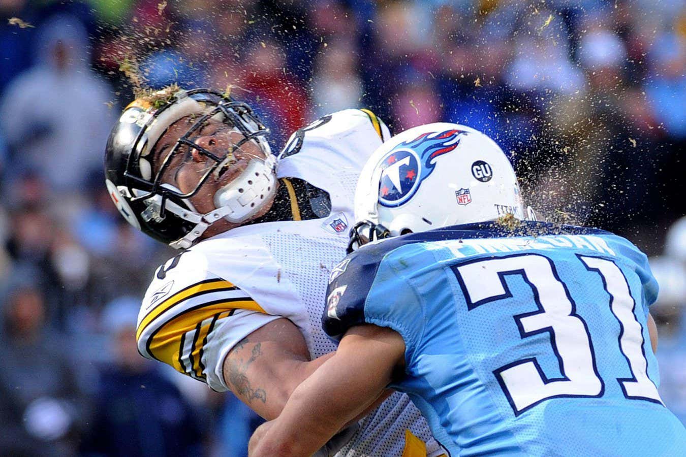 2P7YWKC FILE -- This is a Dec. 21, 2008, file photo showing grass and dirt flying as Pittsburgh Steelers wide receiver Hines Ward, left, is hit by Tennessee Titans' Cortland Finnegan (31) as Ward scores a touchdown on a 21-yard reception in the third quarter of an NFL football game in Nashville, Tenn. (AP Photo/John Russell, File)