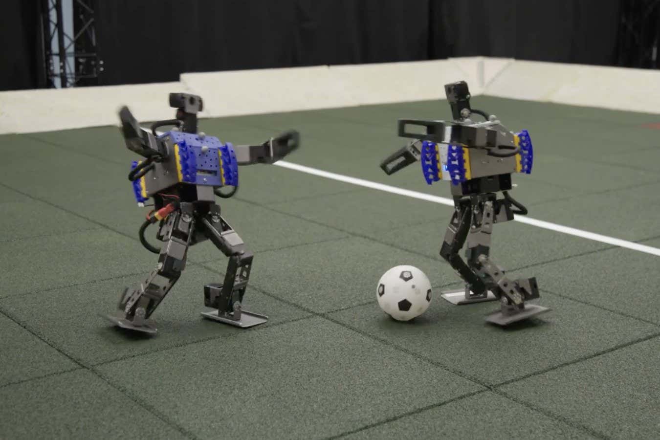 Two mini humanoid robots show off their football skills