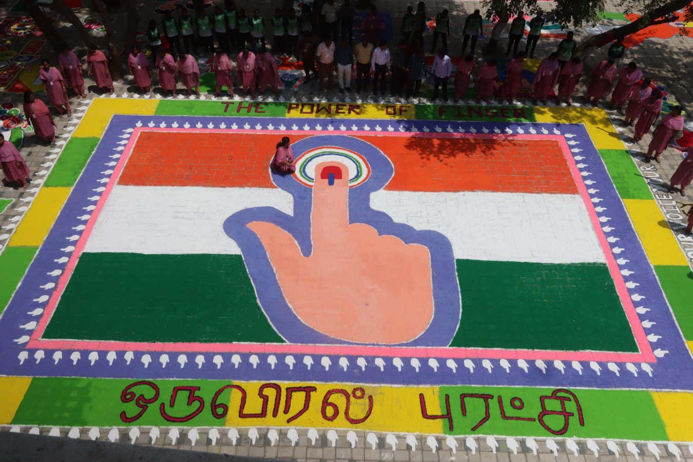 2WXAN77 Chennai, India. 29th Mar, 2024. The Power of Thumb during election depicted by a traditional art work of coloured powder, showing Indian flag and a woman's finger marked with indelible ink to raise awareness among people to vote in the upcoming general elections in Chennai, Credit: Seshadri SUKUMAR/Alamy Live News