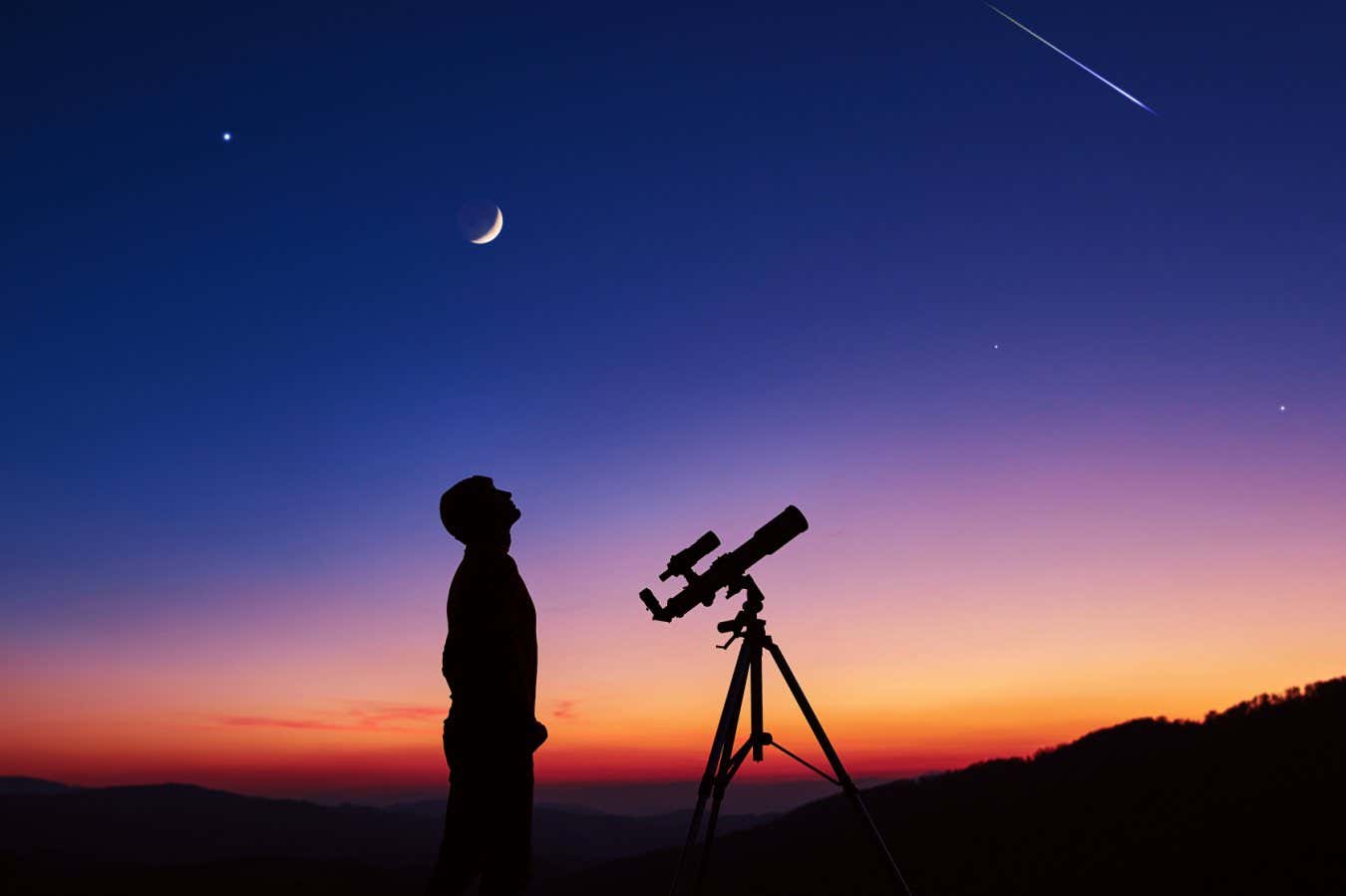 Man with astronomy telescope looking at the night sky, stars, planets, Moon and shooting stars.; Shutterstock ID 2244243077; purchase_order: -; job: -; client: -; other: -