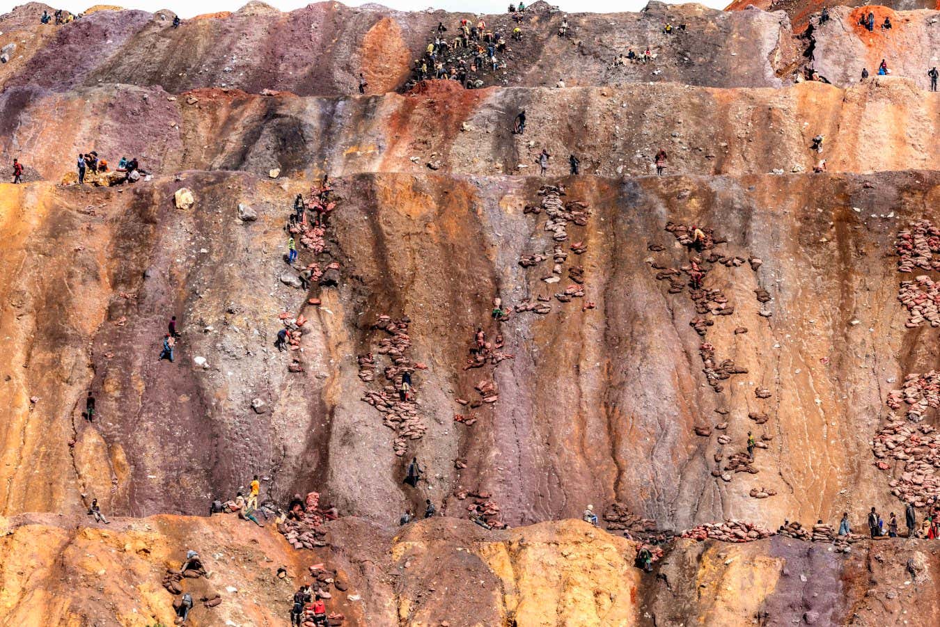 In the village of Tshabula, villagers search for cobalt and copper in the waste tailings dumped by the lorries of the Chinese company Commus, which extracts minerals from one of the town's largest open-cast mines.