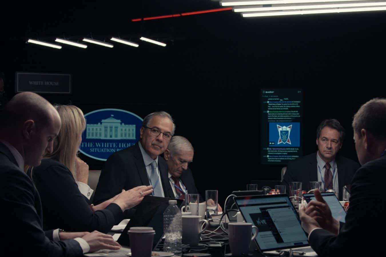 WAR GAME STILL 4 Credit: Thorsten Thielow | Shown in photo: (L to R) Simulation note taker, Elizabeth Neumann, Lou Caldera, Wes Clark, Steve Bullock, Linda Singh, Gwen Camp, David Priess, Pete Strzok