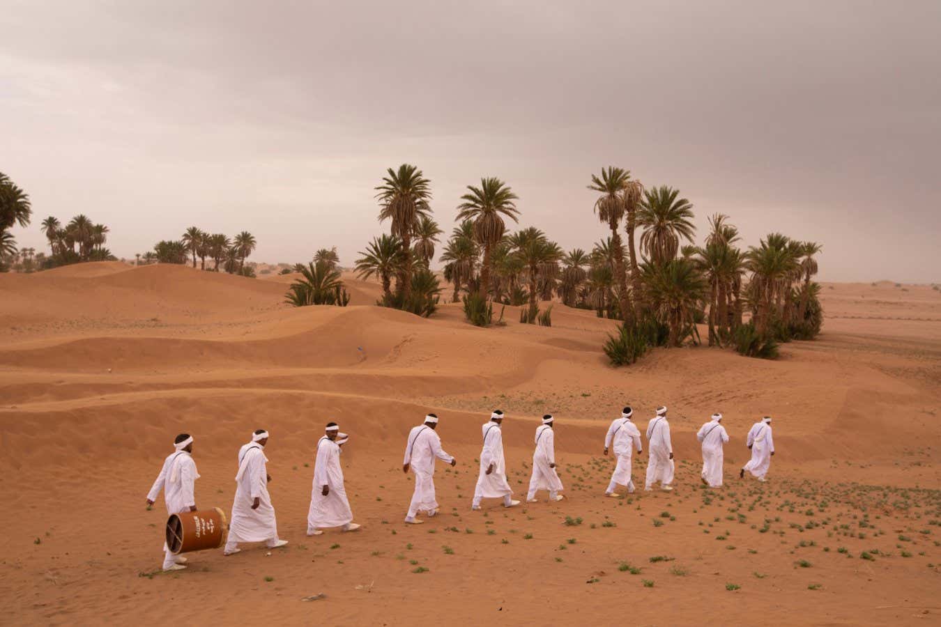 Morocco - M?hamid - Traditional amazigh musicians walk in the desert while performing a traditional rain chant . The amazigh culture is oral and music plays a big part in transmitting the cultural heritage of the tribe. They sing their love for the desert and recount the days when they were nomads.